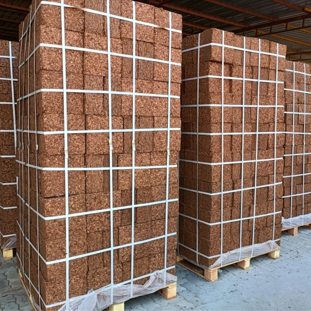 Coco husk chips blocks stacked and strapped on pallets